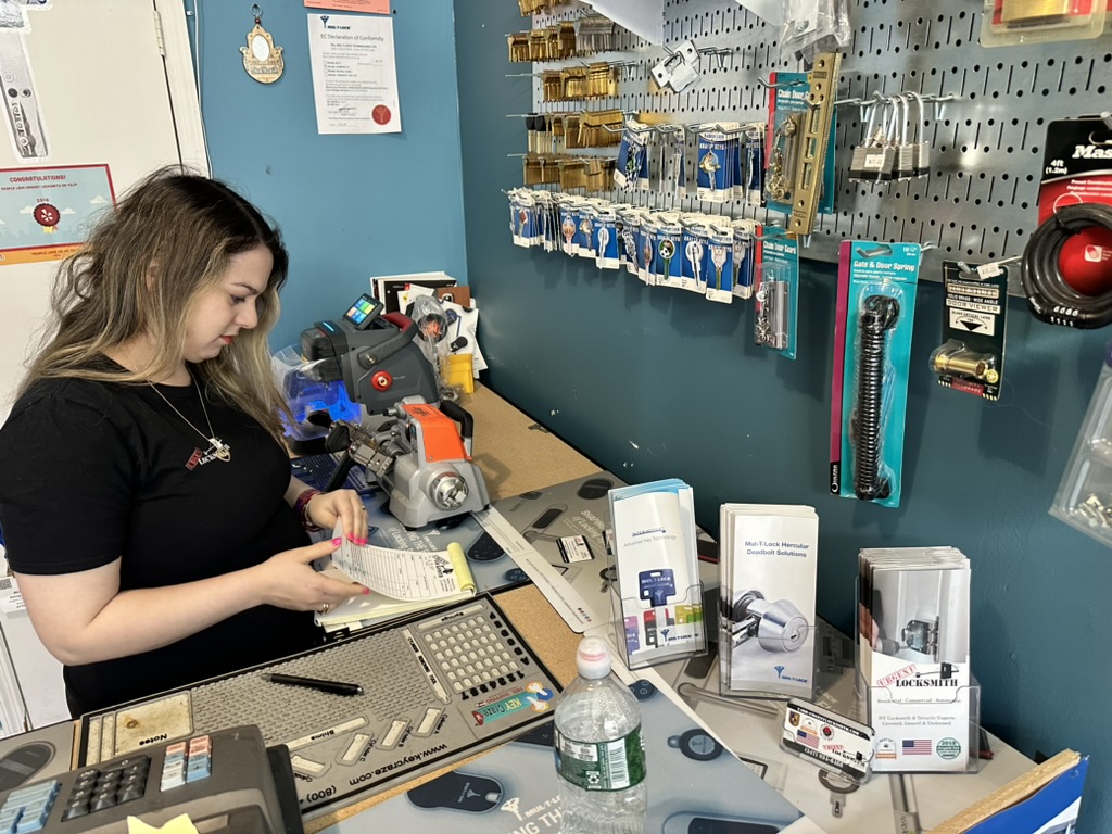 Locksmith cutting keys inside the KeyMobile Locksmith Brooklyn shop